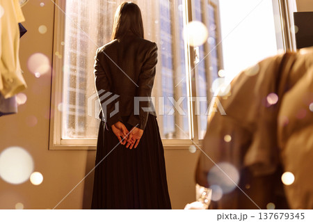 窓辺で佇む女性の後ろ姿 137679345