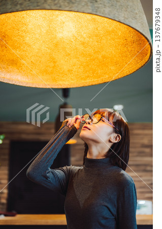 女性が照明を見上げる仕草 女性が照明を見上げる仕草 137679348