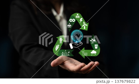 Business Professional Demonstrating Sustainability Concepts with Green Recycling Symbols and Iconic Global Awareness Graphics in a Dark Setting Quark 137679822
