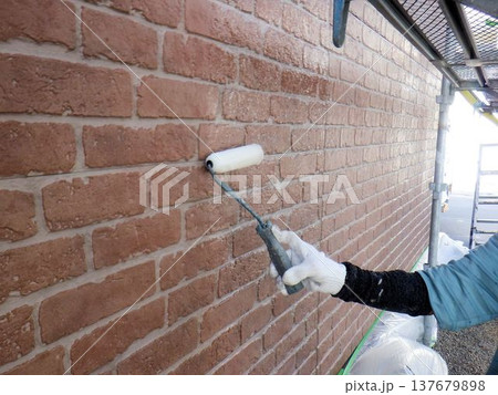住宅の外壁塗装 職人がローラーで塗り替える様子 137679898