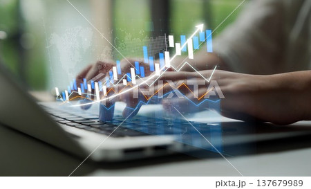 Close-up of hands typing on a laptop keyboard with digital graphs and financial data overlay representing growth and analysis in a modern office environment Copula 137679989