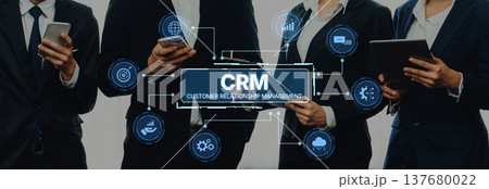 Group of business professionals discussing customer relationship management strategies with digital devices in modern corporate environment Trope 137680022