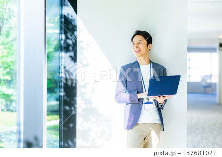 ノートパソコンを持ったビジネスマン 137681021