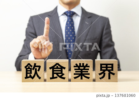 「飲食業界」と書かれたブロックとビジネスマン 「飲食業界」と書かれたブロックとビジネスマン 137681060