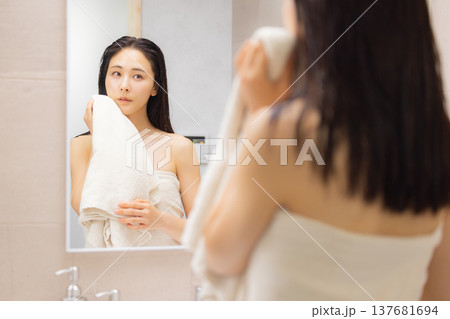 洗面所で肌のチェックをする女性 137681694