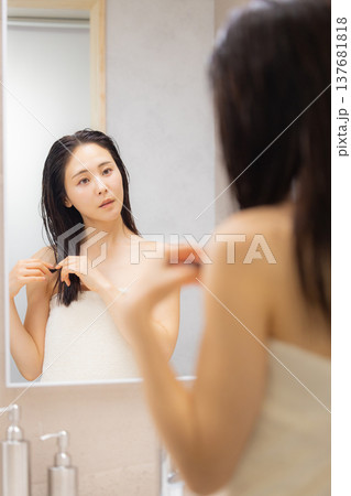 洗面所でヘアケアをする女性 137681818