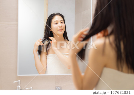 洗面所でヘアケアをする女性 137681821