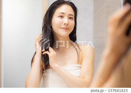 洗面所でヘアケアをする女性 137681823