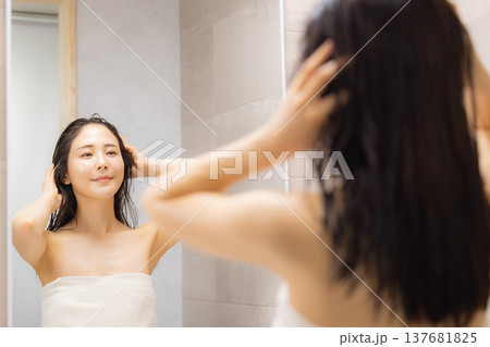 洗面所でヘアケアをする女性 洗面所でヘアケアをする女性 137681825
