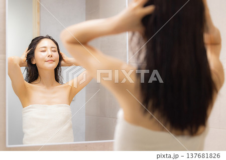 洗面所でヘアケアをする女性 洗面所でヘアケアをする女性 137681826
