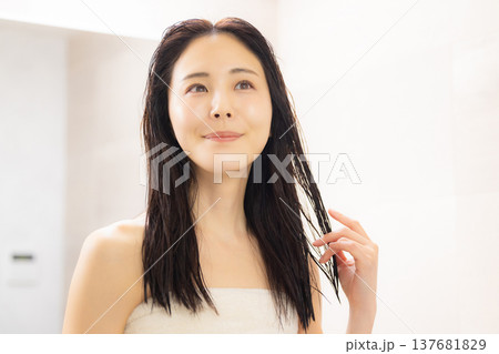 洗面所でヘアケアをする女性 137681829