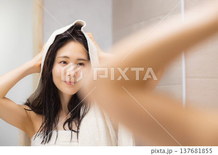 洗面所でヘアケアをする女性 洗面所でヘアケアをする女性 137681855