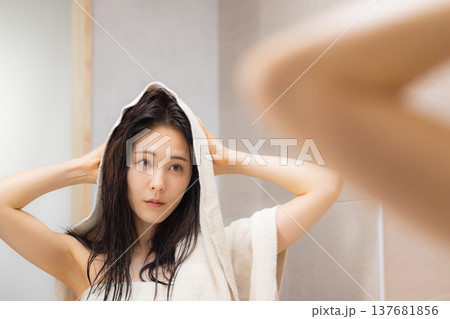 洗面所でヘアケアをする女性　 137681856