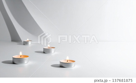 真っ白な空間に数個の小さなティーライトキャンドルが等間隔に並んで灯っている 137681875
