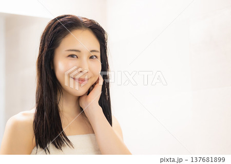 洗面所でスキンヘアケアをする女性 洗面所でスキンヘアケアをする女性 137681899