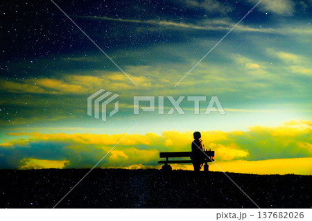 夕焼けの丘に座る女性のシルエットと星空 夕焼けの丘に座る女性のシルエットと星空 137682026