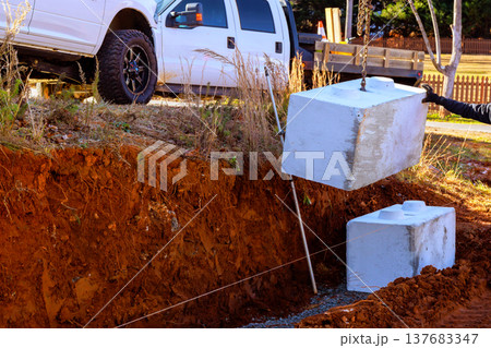Heavy concrete blocks are being lowered into prepared excavation site at retaining walls 137683347