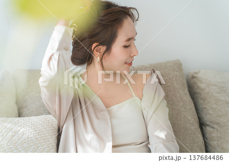 リビングのソファでリラックスするおしゃれな主婦のアジア人女性 137684486