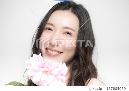 ダリアの花を持って多幸感にあふれるピンクの春色イメージの女性の美容ビューティーイメージ ダリアの花を持って多幸感にあふれるピンクの春色イメージの女性の美容ビューティーイメージ 137685059