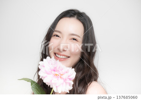 ダリアの花を持って多幸感にあふれるピンクの春色イメージの女性の美容ビューティーイメージ ダリアの花を持って多幸感にあふれるピンクの春色イメージの女性の美容ビューティーイメージ 137685060