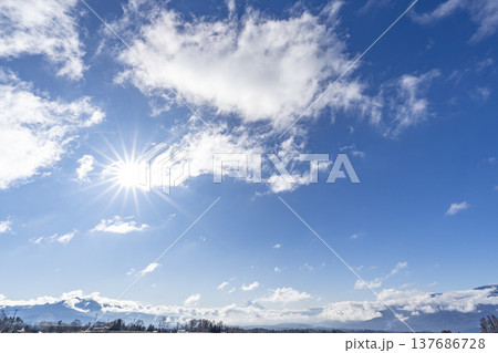 青空に輝く太陽と山並み 137686728