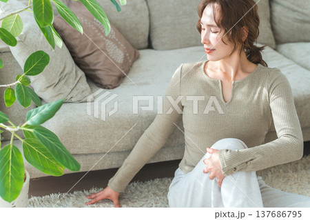 自宅のリビングでストレッチ,柔軟をする女性 自宅のリビングでストレッチ,柔軟をする女性 137686795