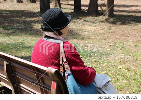 公園のベンチに座る高齢者の後ろ姿 公園のベンチに座る高齢者の後ろ姿 137686819