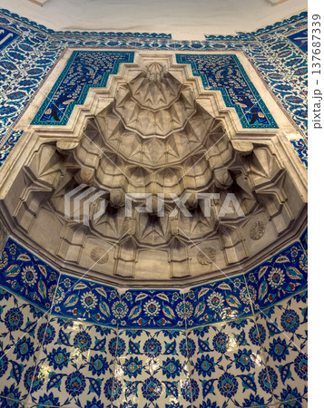 Intricate architectural design featuring blue and white tile work and a detailed stone fountain in a historical building interior Intricate architectural design featuring blue and white tile work and a detailed stone fountain in a historical building interior 137687339