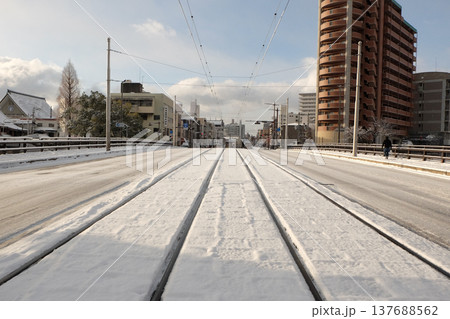 雪に覆われた路面電車の軌道と冬の都市景観 ― 広島市横川新橋 137688562