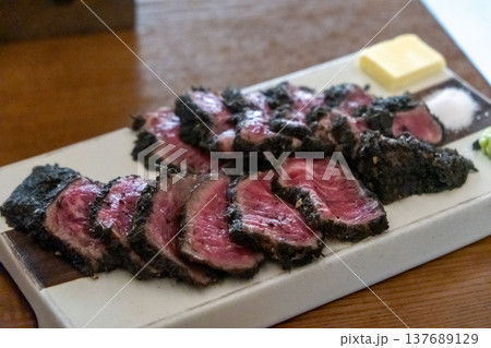 Set of Black Gyukatsu or beef cutlet served with butter. A traditional Japanese food that consists of a deep-fried beef cutlet. 137689129