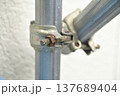 錆びたボルトで固定された工事現場の足場用金属クランプ（自在クランプ） 137689404