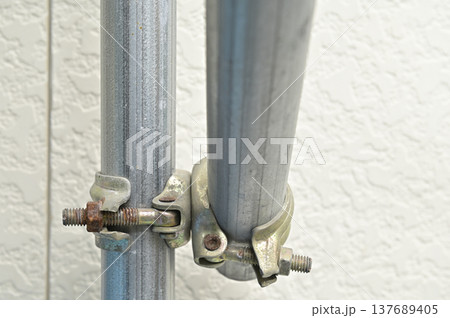 単管パイプを固定する直交クランプと錆びたボルト 137689405