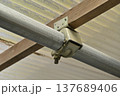 単管パイプと木材を固定するジョイント金具（垂木止めクランプ）のアップ 137689406