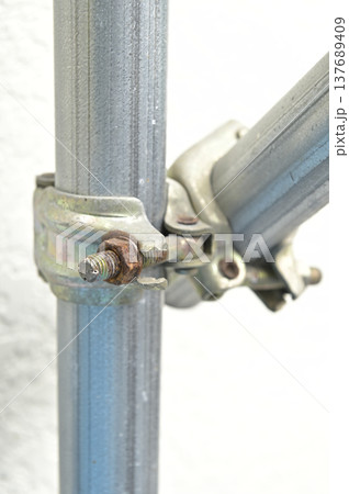 建設現場の足場用クランプと単管パイプのアップ（錆びたボルト） 137689409