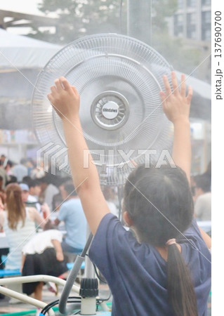 ミスト発生機に近寄ってミストを浴びる子ども ミスト発生機に近寄ってミストを浴びる子ども 137690700