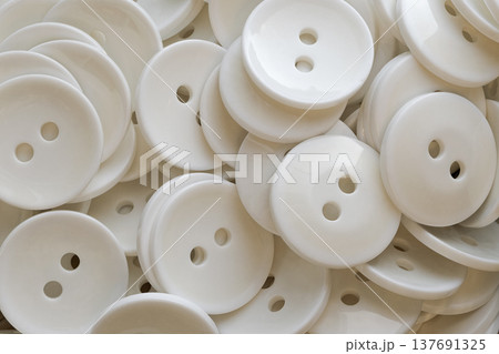 A lot of identical round white buttons A lot of identical round white buttons 137691325