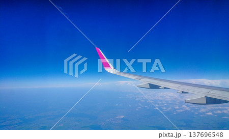 Plane wing glides above fluffy white clouds 137696548