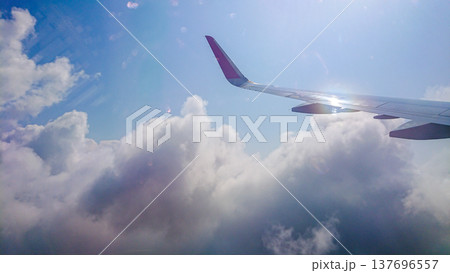 Plane wing glides above fluffy white clouds 137696557