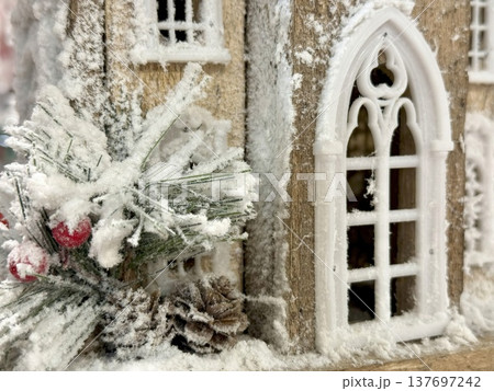 frosted miniature gothic cottage with snowy pine berries and cone for holiday web design 137697242