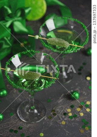 Green Cocktails with Lime, Gifts and Confetti. Festive St. Patricks Day Celebration Still Life Green Cocktails with Lime, Gifts and Confetti. Festive St. Patricks Day Celebration Still Life 137697333