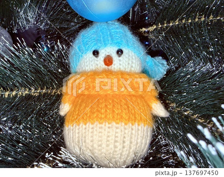 adorable knitted penguin christmas ornament hanging on evergreen tree with blue bauble evoking joyful holiday cheer perfect for seasonal wallpaper or festive social media banner adorable knitted penguin christmas ornament hanging on evergreen tree with blue bauble evoking joyful holiday cheer perfect for seasonal wallpaper or festive social media banner 137697450