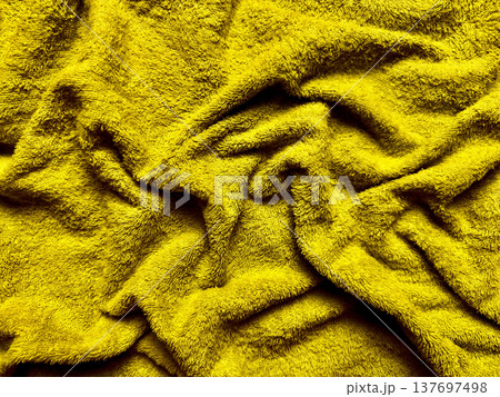 vibrant yellow terrycloth folds in macro texture closeup evoking cozy warmth for spa banner backgrounds or wellness wallpaper designs 137697498