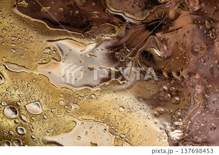 Earthy brown fluid marble texture with shimmering waves macro shot 137698453