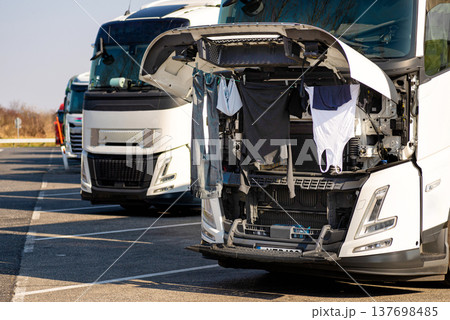 Drying clothes under the hood of a truck. 137698485