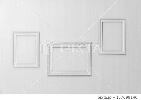 An arrangement of three white empty picture frames An arrangement of three white empty picture frames 137699140