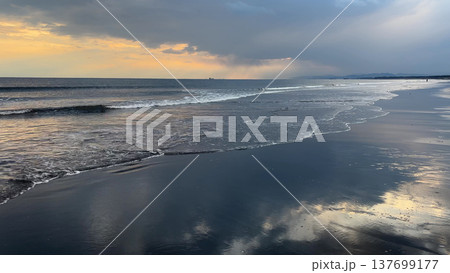 夕暮れの空に広がる雲と波打ち際に写った夕暮れの空と光を反射した雲 夕暮れの空に広がる雲と波打ち際に写った夕暮れの空と光を反射した雲 137699177