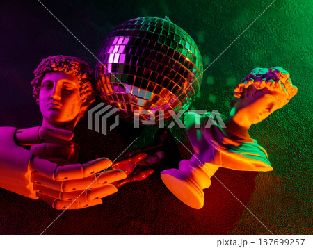Classical sculpture busts with disco ball under vibrant neon lighting creating retro atmosphere 137699257
