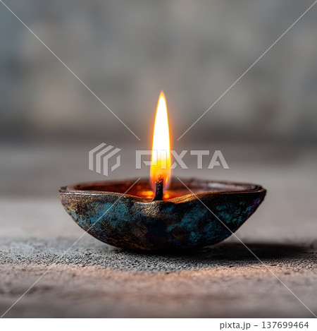 Single diya in center of clean neutral background, soft focus on flame, pastel ambient lighting 137699464
