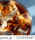Close-up of swirling milk mixing into cold brew coffee, visible ice cubes, bright daylight, natural minimal tones 137699487