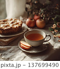 Cup of herbal tea and apple slices near a freshly baked pie, warm morning light, cozy soft aesthetic, fall lifestyle mood 137699490